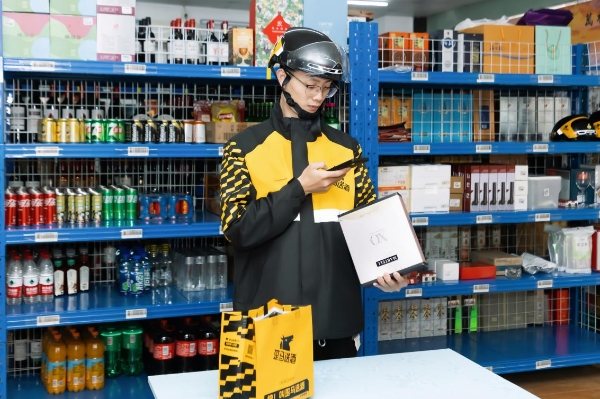 Un livreur prépare une commande de boissons dans un point de vente dédié à la livraison instantanée